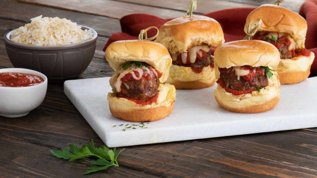 Three meatball sliders with marinara and cheese