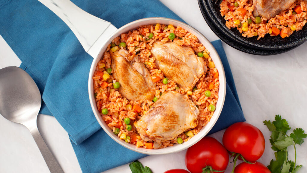 Traditional arroz con pollo with chicken thighs, peas and stewed tomatoes