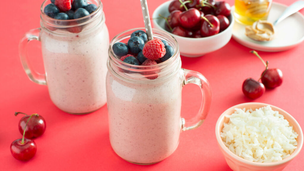 Jarra con smoothie de desayuno de arroz y mantequilla de cacahuate con frutas del bosque