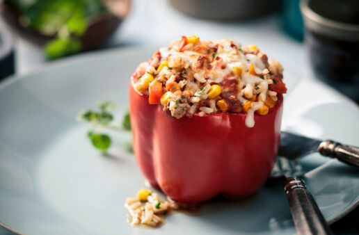 Stuffed red bell pepper with rice, corn and turkey topped with cheese