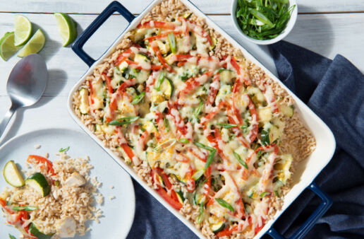 White casserole and plate with brown rice and vegetables topped with grated cheese