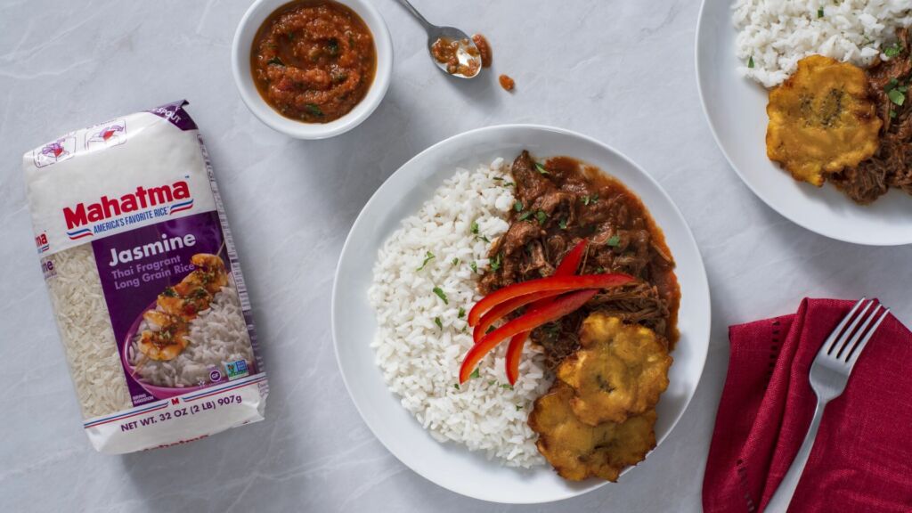 Shredded flank steak and vegetables with tomato-based sauce, fried plantains and Jasmine Rice