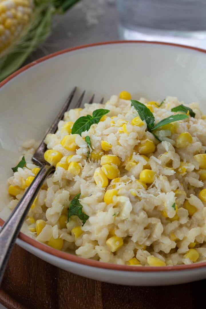 sweet corn risotto with a fork and herbs