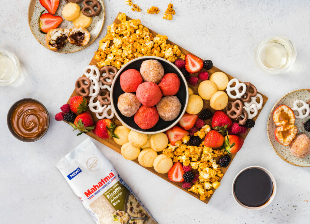 colorful-dessert-board-with-sweet-arancini-fresh-fruit-caramel-pop-corn-and-pretzels